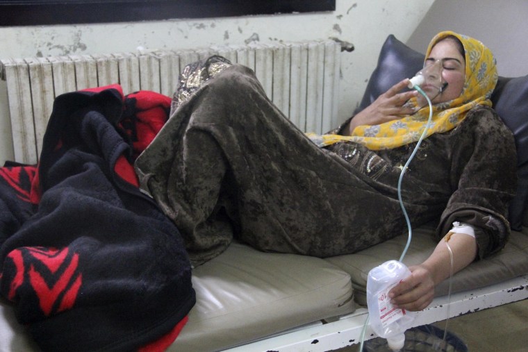 Image: A woman breathes through an oxygen mask inside a field hospital in Kfar Zeita village in the central province of Hama