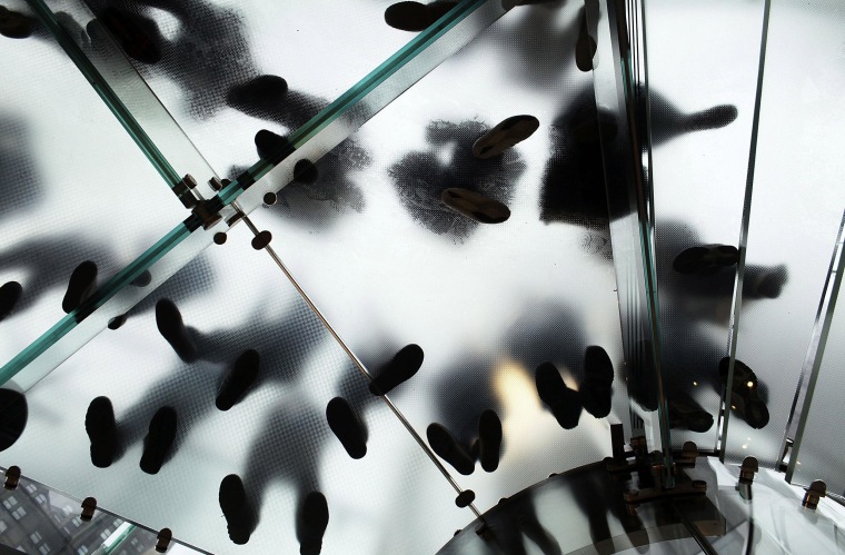 Image: People stand on a glass staircase