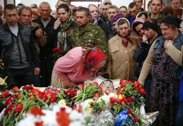 Image: People stand around coffin of man killed in gunfight on April 20 during funeral ceremony in Slaviansk