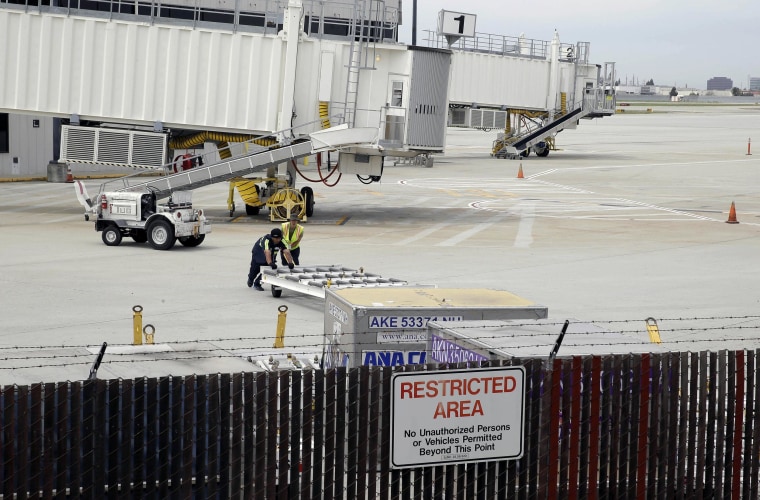 Image:Workers move equipment near gates used by Hawaiian Airlines at Terminal A