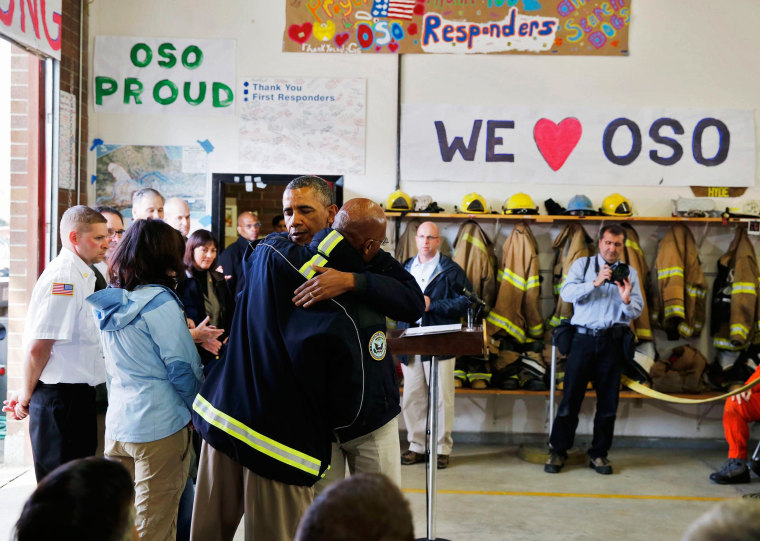 Image: U.S. President Barack Obama hugs a first responder after touring the mud slide damage in Oso, Washington