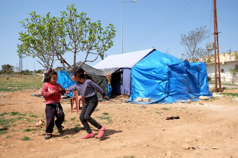 Hoda's daughters, Najua and Saga play in front of their tent in Kilis, Turkey