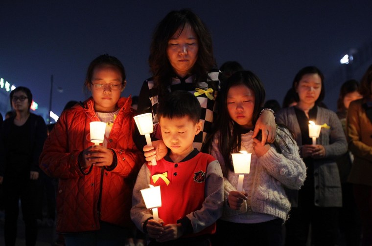Image: Students and citizens hold candles as they pray for the missing passengers on the doomed South Korean ferry