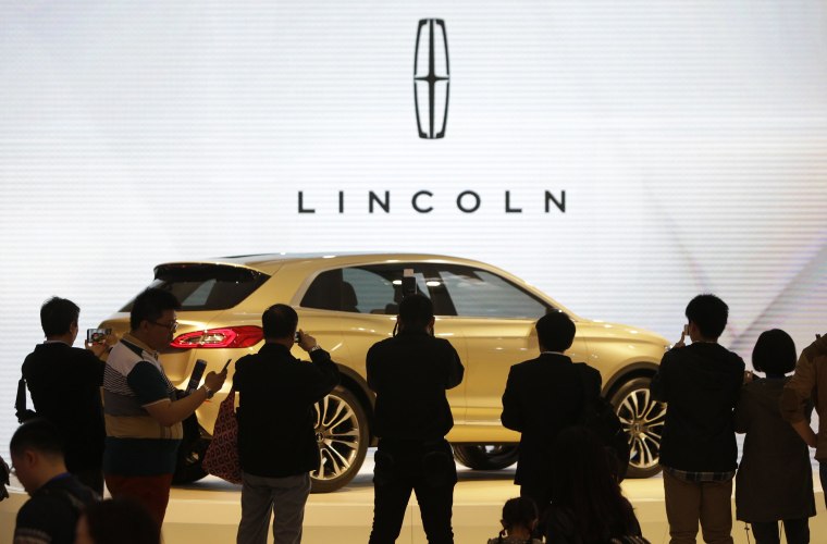 Visitors take photos of a Lincoln MKX SUV concept car at Auto China 2014 in Beijing