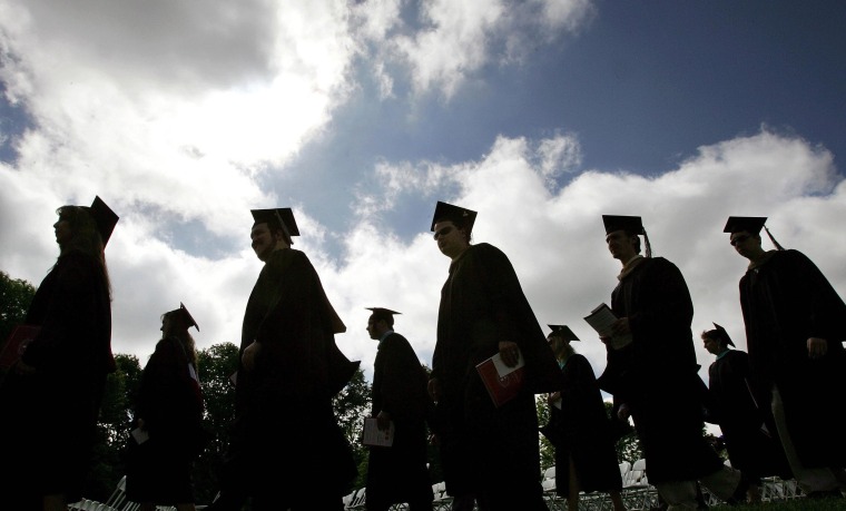 Image: Students in their caps and gowns are silhouetted as they line up for graduation ceremonies.