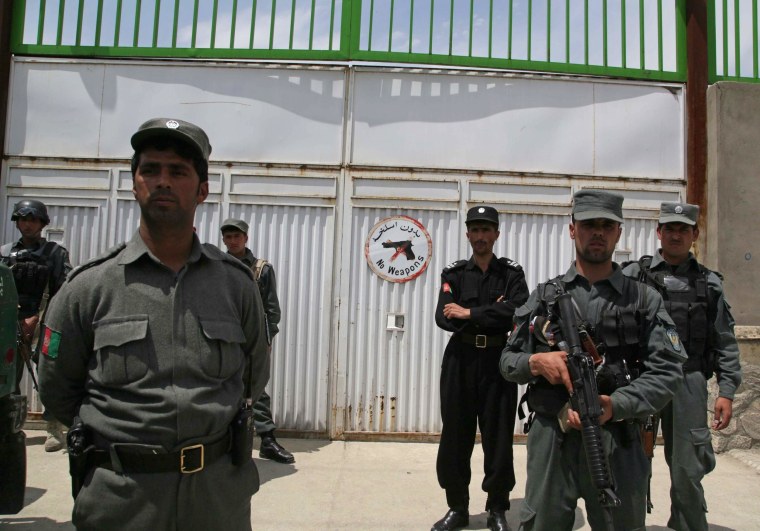 Image: Afghan security officials stand guard outside the Cure hospital in Kabul
