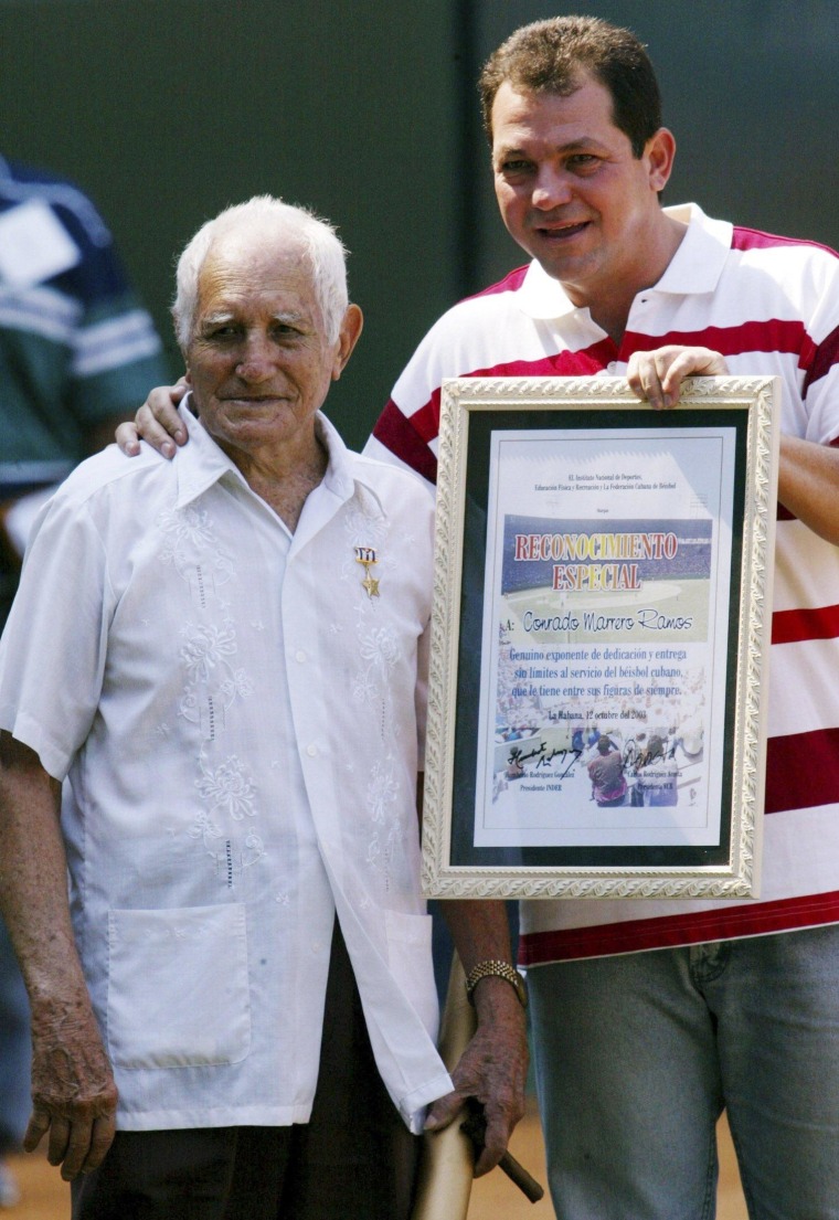 Image: File photo of veteran baseball player Conrado Marrero standing next to Humberto Rodriguez, president of the Cuban Sports Federation in Havana