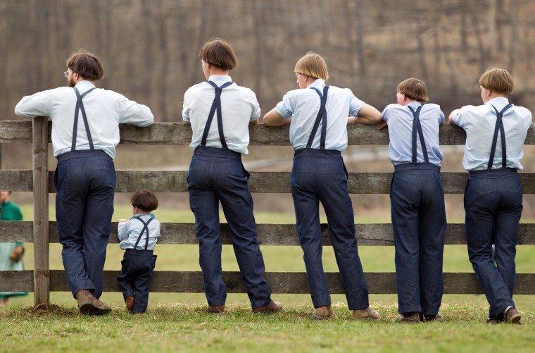 Image: Amish boys watch a game of baseball outside the school