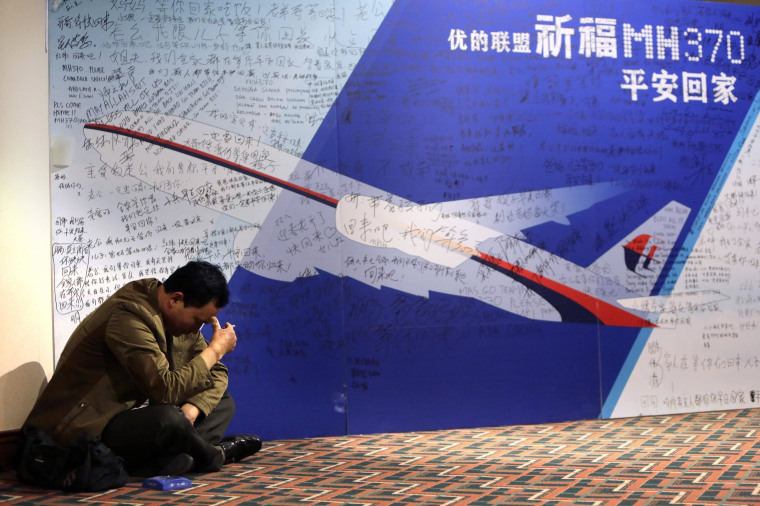 Image:A family member of a Flight 370 passenger sits near message board at Lido Hotel in Beijing on March 29