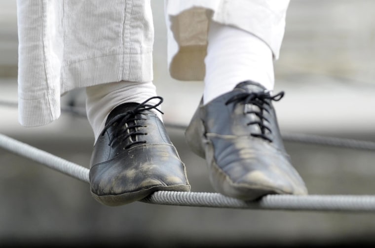 Image: A tightrope walker performs above a canal in Brussels