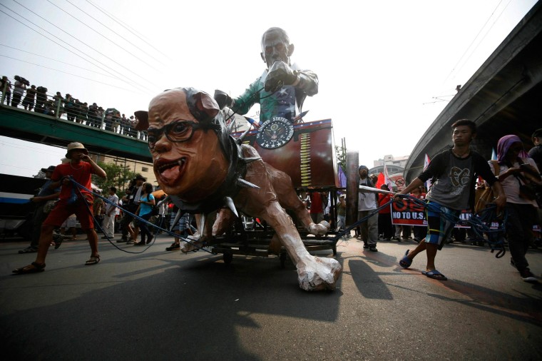 Image: Activists drag effigy of the Philippine's President Aquino and U.S. President Obama as they march along a main road towards the presidential palace in Manila