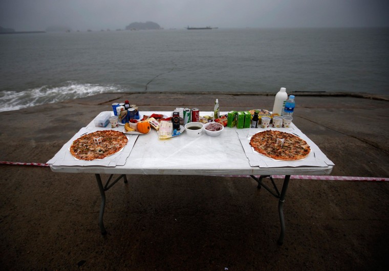 Image: Pizzas are placed among other food offerings on altar dedicated to missing and dead passengers on board capsized Sewol ferry, at a port in Jindo