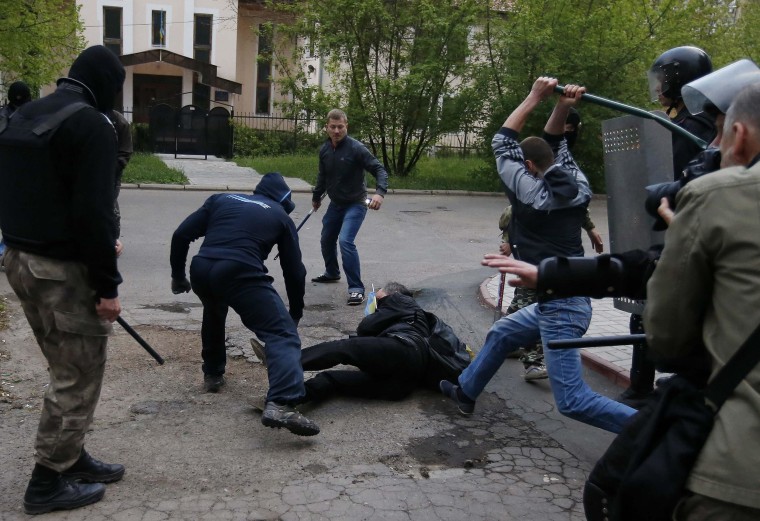Image: Pro-Russian protesters attack a pro-Ukranian protester during a pro-Ukraine rally in the eastern city of Donetsk