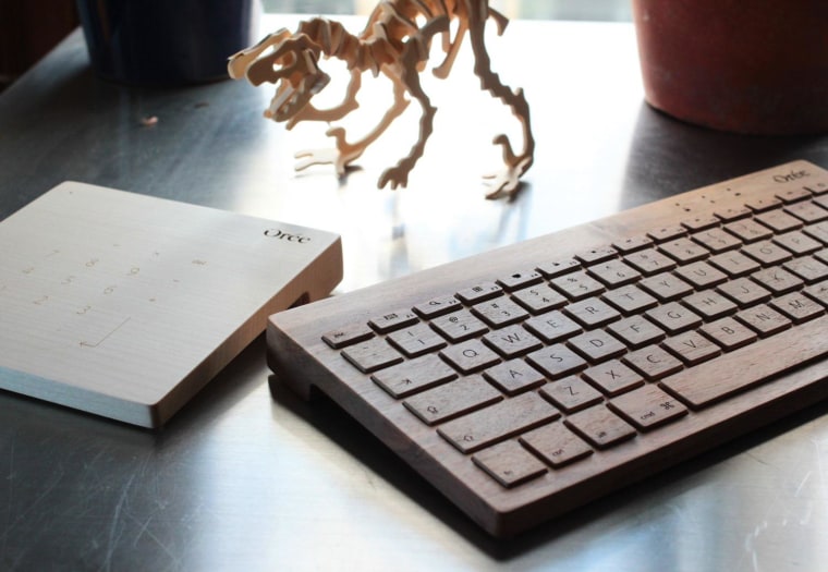 The base and each key are cut from a single piece of wood, keeping grain and patterns in line.