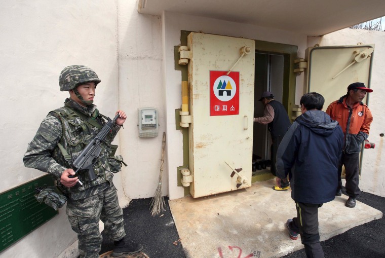 Image: A South Korean soldier stands watch as residents of Socheong Island evacuate to a shelter
