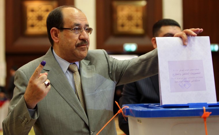 Image: Iraqi Prime Minister Nouri al-Maliki shows his ink-stained finger as he casts his vote