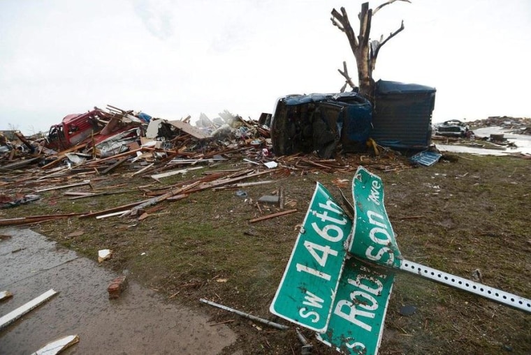 IMAGE: A twisted street sign lay atop wreckage in a destroyed neighborhood in Moore, Okla., after a monster tornado in May 2013.