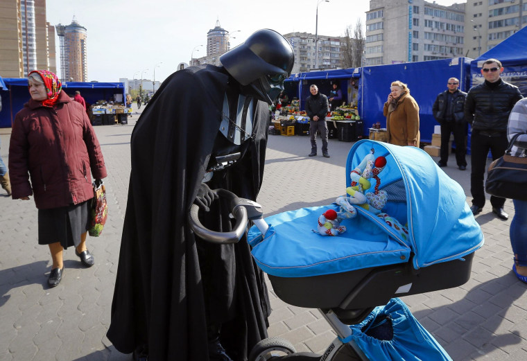 Image: "Darth Vader", the leader of the Internet Party of Ukraine, looks at a child in a pram at a street market near the Ukrainian Central Elections Commission in Kiev