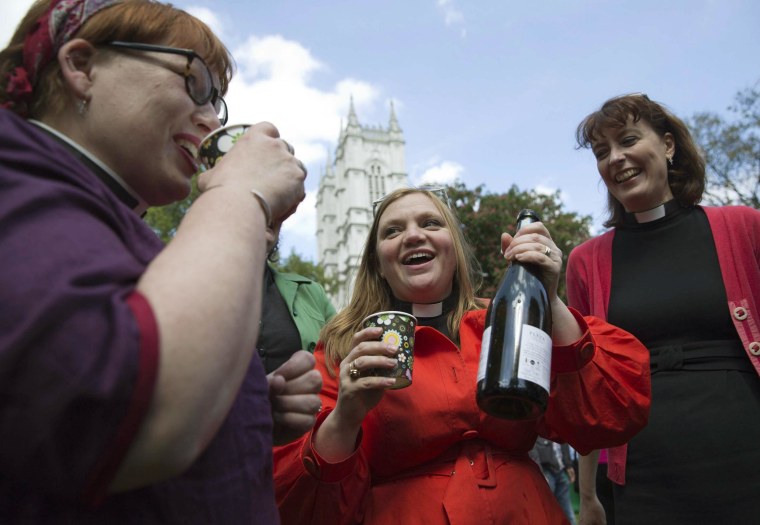 Image: Female priests toast a drink before a march celebrating the 20th anniversary of women becoming ordained priests in the Church of England in London