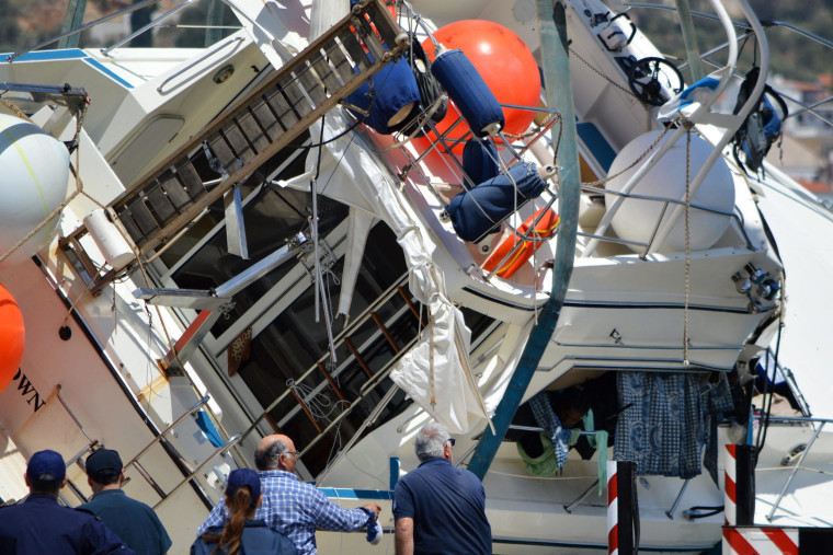 Image: A crane lifts a yacht after it capsized off the Greek island of Samos on Monday