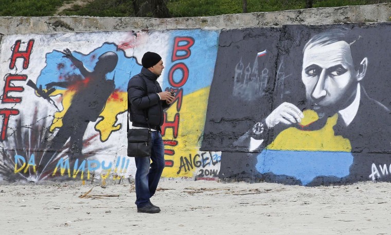 Image: A man looks at a graffiti produced to support the territorial integrity of Ukraine and to protest Russia's annexation of Crimea in Odessa