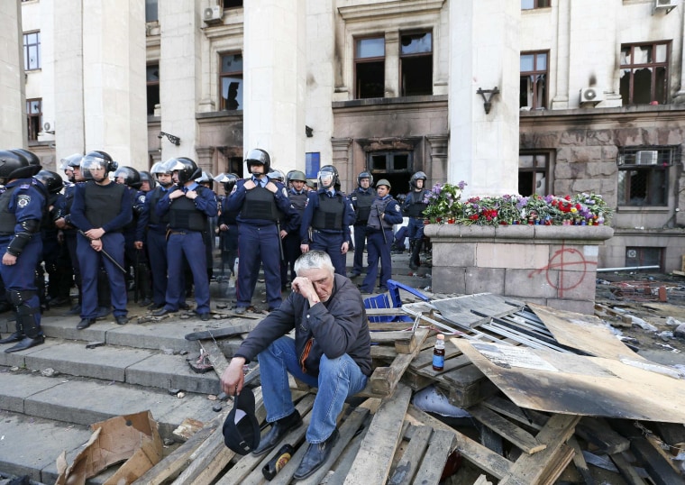 Image: A man reacts outside trade union building, where a deadly fire occurred, in Odessa.