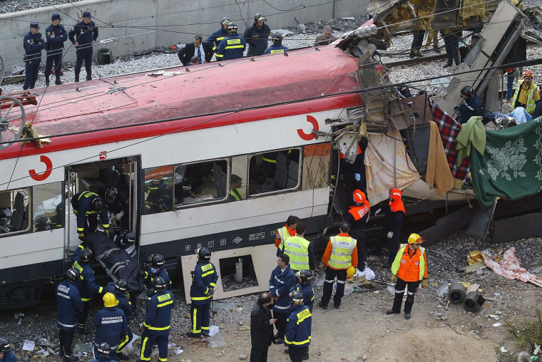 Image: Rescue workers evacuating the body of a victim after a train exploded at the Atocha train station in Madrid