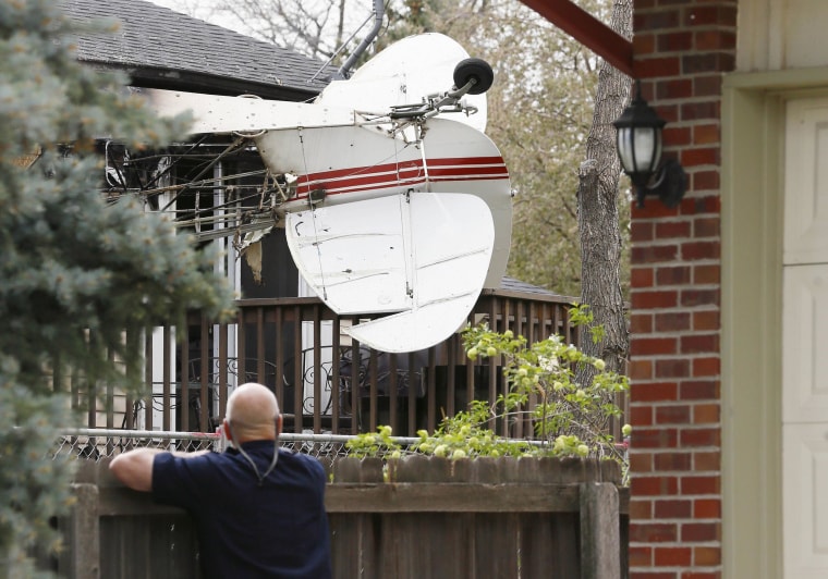 Image: Tim Hanlon looks at the wreckage of a small plane that crashed into a house in Northglenn, Colo.