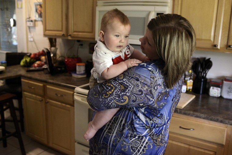 Image: Jenessa Moman holds her son Landyn Rich, 9 months