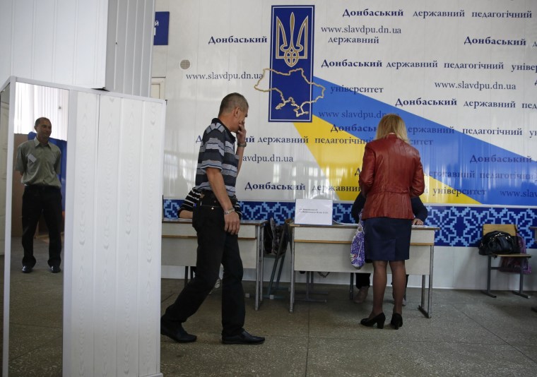Image: People visit a polling station to take part in a referendum on the status of the Donetsk region in Slaviansk