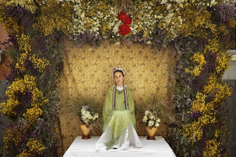 Image: A 'Maya' girl sits on an altar during the traditional celebration of 'Las Mayas' on a street, in central Madrid, Spain
