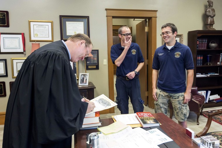Image: Judge Herbert Wright signs the marriage license of Steven Gibson and Mark Hightower in the Judges chambers at the Pulaski County Courthouse in Little Rock
