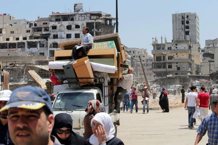 Image: Residents of the Old City of Homs ferry items out from their destroyed neighborhood on May 12