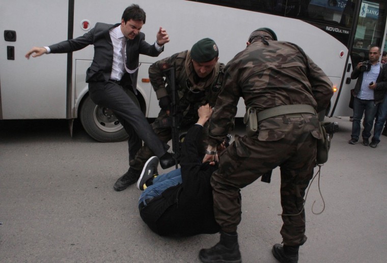 Image: A protester is kicked by Yusuf Yerkel, advisor to Turkey's Prime Minister Tayyip Erdogan, as Special Forces police officers detain him during a protest against Erdogan's visit to Soma