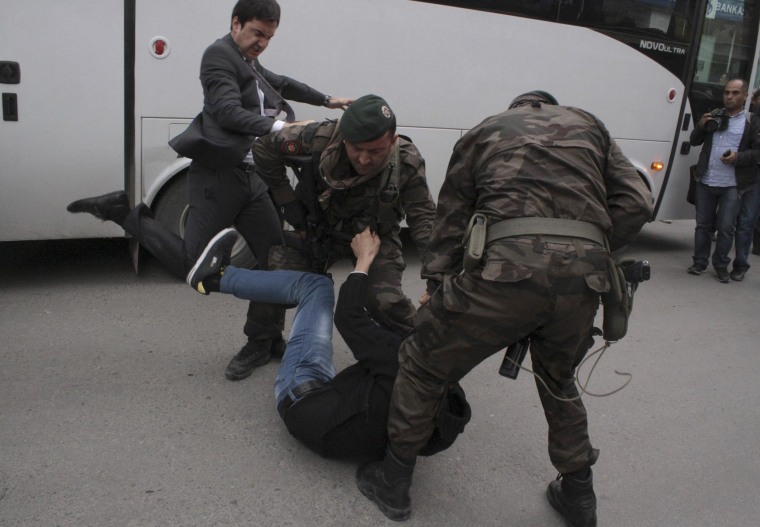 Image: A protester is kicked by Yusuf Yerkel, advisor to Turkey's Prime Minister Tayyip Erdogan, as Special Forces police officers detain him during a protest against Erdogan's visit to Soma