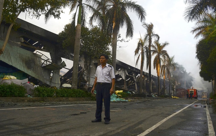 Image: A security guard stands near a damaged Chinese-owned shoe factory in Vietnam's Binh Duong province