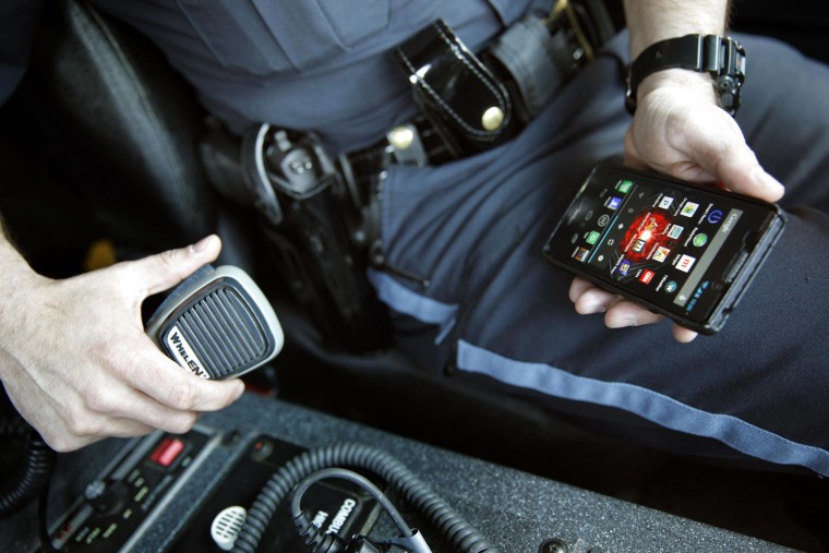 Image: A member of the Kalamazoo Dept. of Public Safety is seen in his armored vehicle holding his cell phone