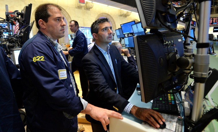 Traders work at the New York Stock Exchange on Thursday where the Dow fell over 1 percent on a handful of negative economic reports.