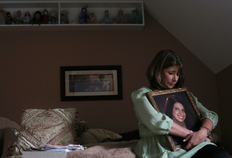 Image: Alicia Stillman holds a portrait of her 19-year-old daughter, Emily, who died in February 2013 from meningitis B.