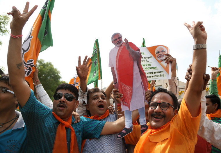 Image: Indian supporters celebrate by dancing and distributing sweets at the Bharatiya Janata Party's state headquarter in Gandhinagar.