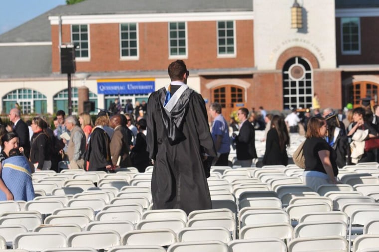 Image: A graduate looks for relatives as people evacuate Quinnipiac University's campus after 'multiple' security threats