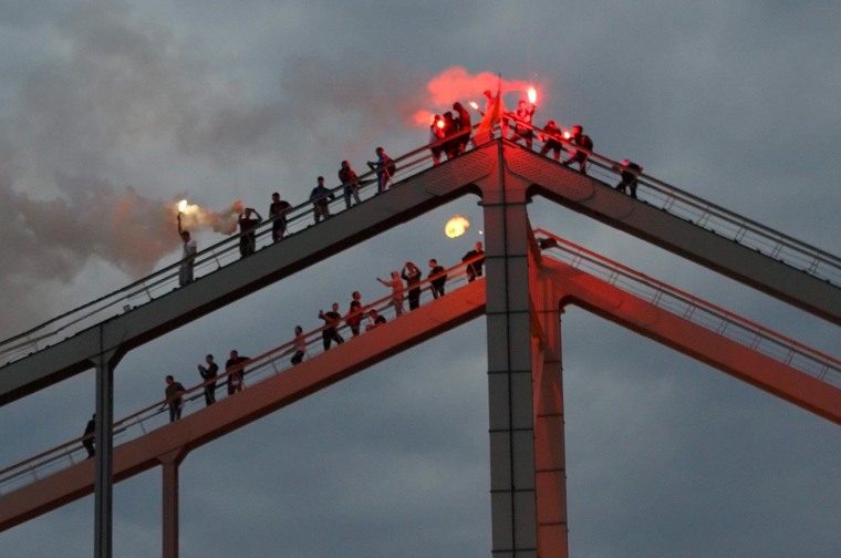 Image: Soccer fans burn torches on a bridge in Kiev, Ukraine