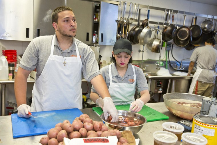 Image: Luis Mateo and Kasandra Vega, both high school dropouts, work in the kitchen of the culinary program of the United Teen Equality Center