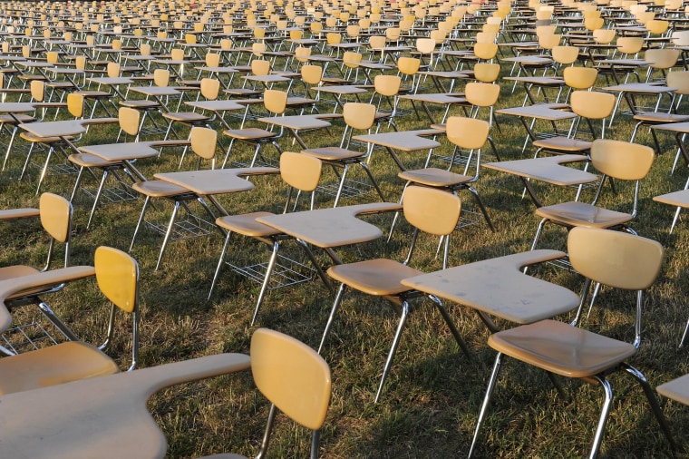 Image: An art installation of 857 empty school desks stands at the National Mall in Washington