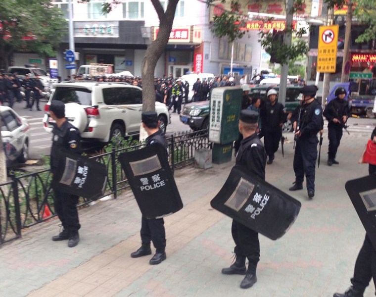 Image: Police officers stand guard near a blast site which has been cordoned off, in downtown Urumqi, capital of northwest China's Xinjiang Uygur Autonomous Region