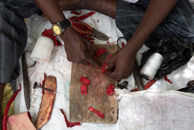 Image: A man makes charms at a camp of a vigilante group of traditional hunters in Maiduguri