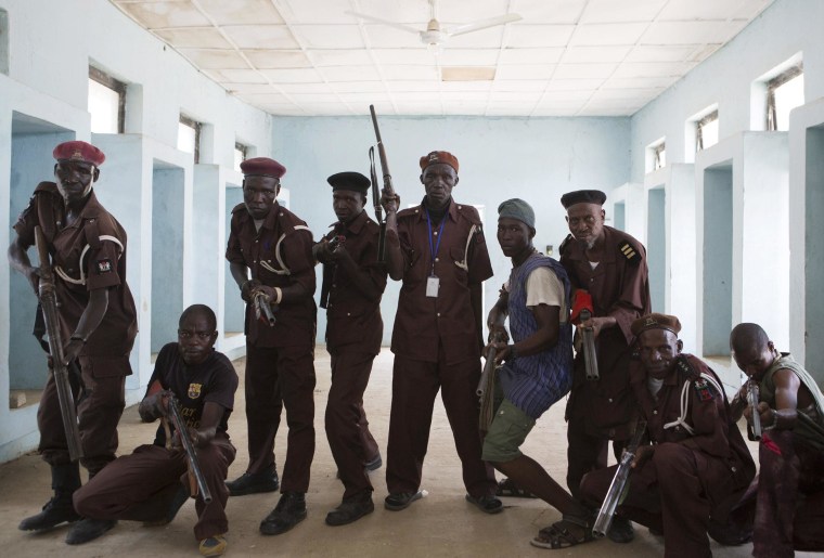 Image: Members of a vigilante group of traditional hunters pose for a picture at their camp in Maiduguri