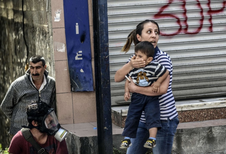 Image: A woman holds her child during clashes in Istnbul