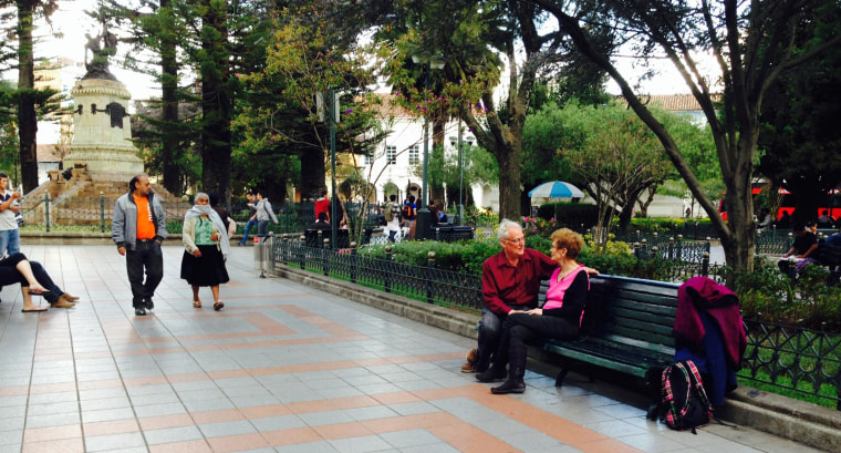 An American couple sits on a park bench in Ecuador.