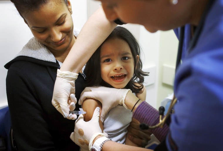 Image: Mercado sits in his mother's lap while getting an influenza vaccine at Boston Children's Hospital in Boston